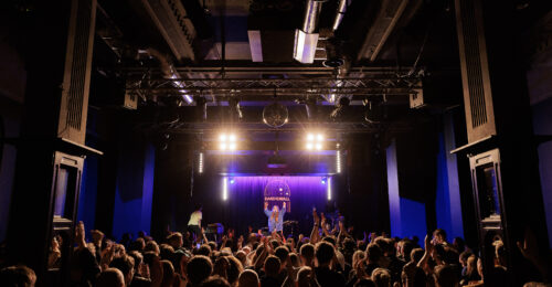 A crowded venue (Band on the Wall) with a performer on stage